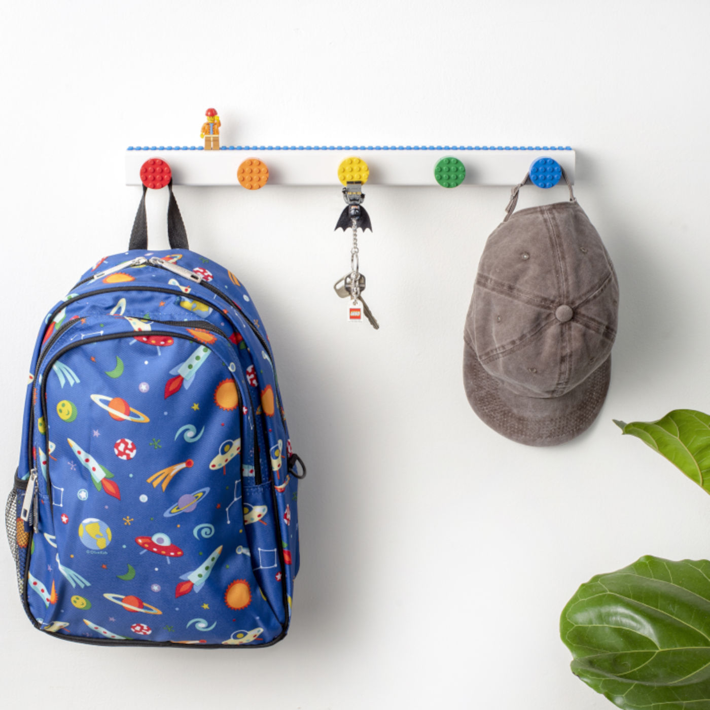 Build-On Brick Wall Hooks installed in an entryway with backpack and hat